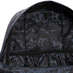 Close-up of the inside of a backpack or bag, showing a black and dark gray printed interior lining with illustrated monster-like graphics and a laptop pocket. 