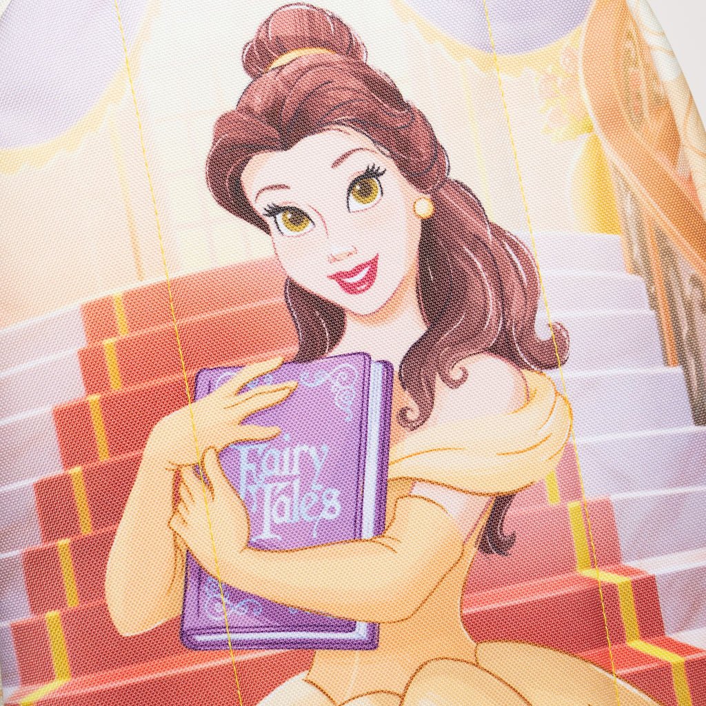 A close-up of WondaPop Disney Belle - Beauty and the Beast 16" School Backpack's back featuring Belle from Beauty and the Beast holding a purple book labeled 'Fairy Tales,' set against red and white stairs with soft pastel background tones.