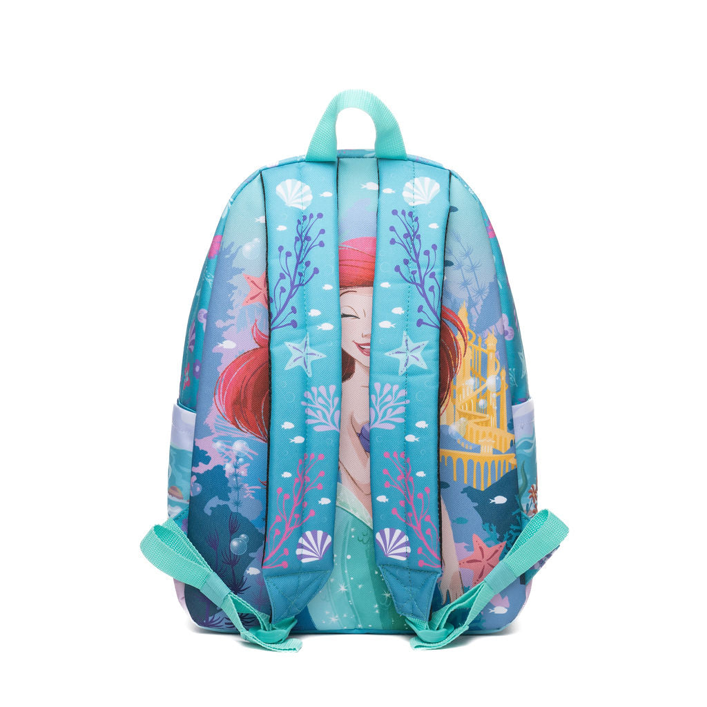 A children's backpack featuring a colorful The Little Mermaid-themed print with Ariel, starfish, seashells, and a golden castle on a blue ocean background, shown against a plain white studio background.