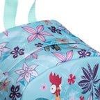 A close-up of a light blue backpack featuring a colorful Hawaiian floral and bird print, including pink and purple flowers and mint green straps against a white background.