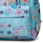 A close-up of a Disney backpack in a light turquoise blue color, decorated with a vibrant floral pattern in pink, purple, orange, and white. The Disney brand name is visible on a stitched patch on the front pocket and on a side tag.