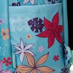 Close-up of a light blue fabric backpack left side pocket with a colorful tropical floral print, including red, orange, purple, and white flowers.
