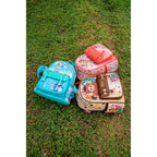 Top-down view of Disney Loungefly mini backpacks featuring Pumbaa, Stitch, and Bambi placed on grass